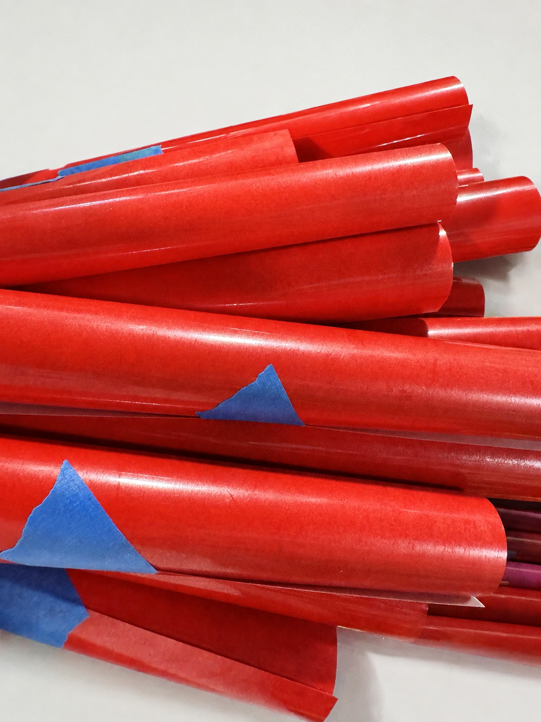 Pile of red Siser heat transfer vinyl rolls with a matte finish