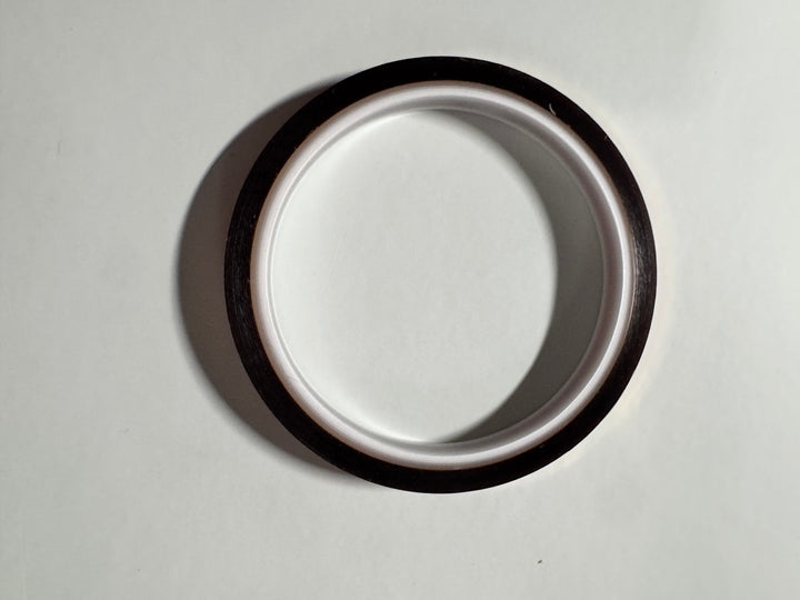 Roll of amber polyimide heat resistant tape on a white core