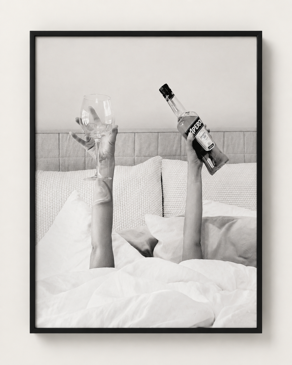 Black and white photograph of champagne in bed, black frame