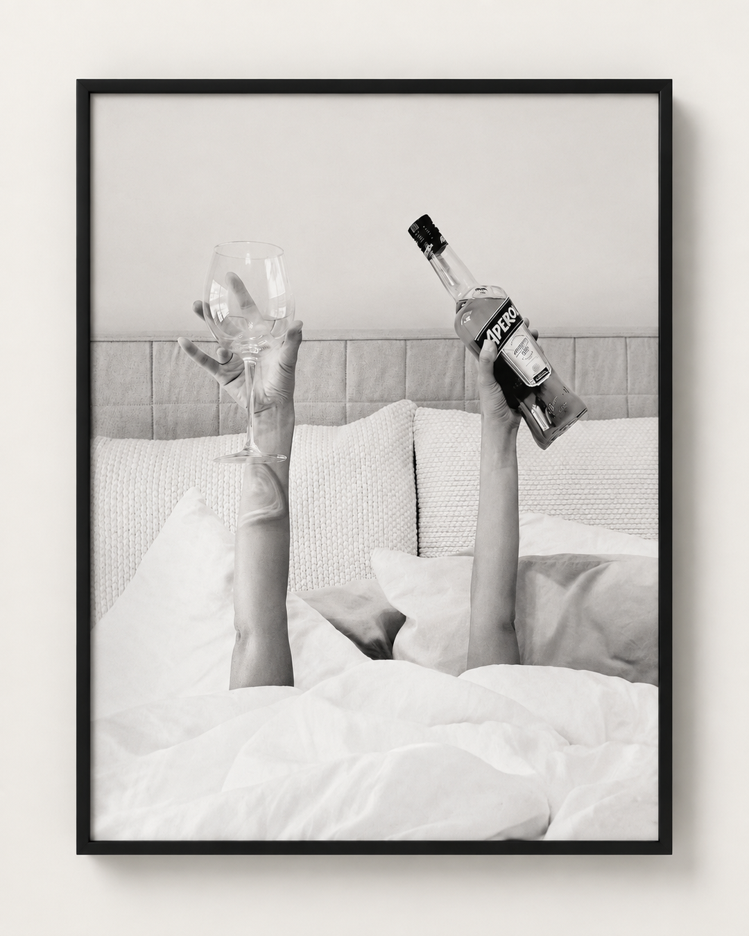 Black and white photograph of champagne in bed, black frame