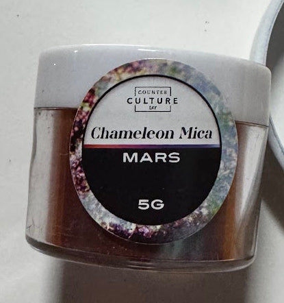 Small clear jar of Creative Culture Mars chameleon mica with a dark red maroon colour shift, 5 g