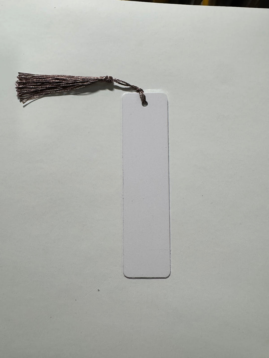 Blank white sublimation bookmark with a square cut end and a burgundy tassel