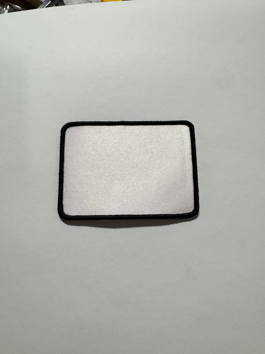 Rectangular sublimation patch blank with a white face and black merrowed border