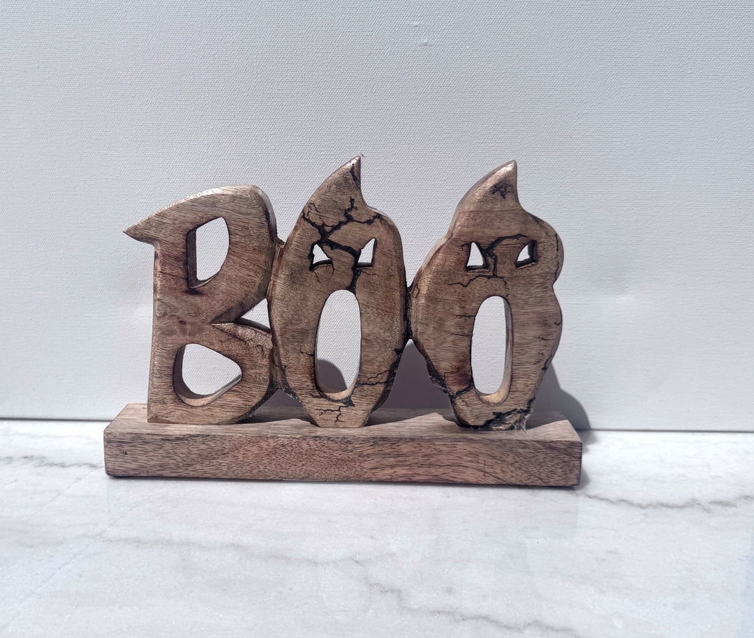 Carved wood BOO sign on a wood base