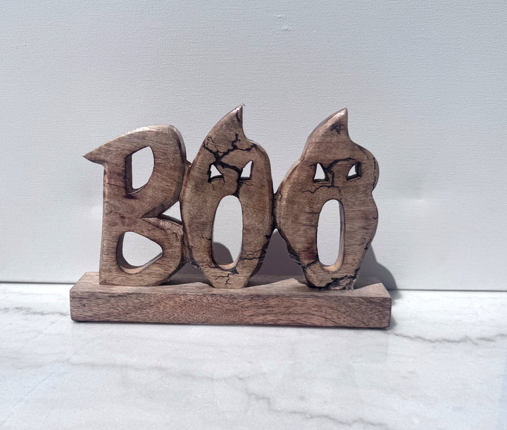 Carved wood BOO sign on a wood base