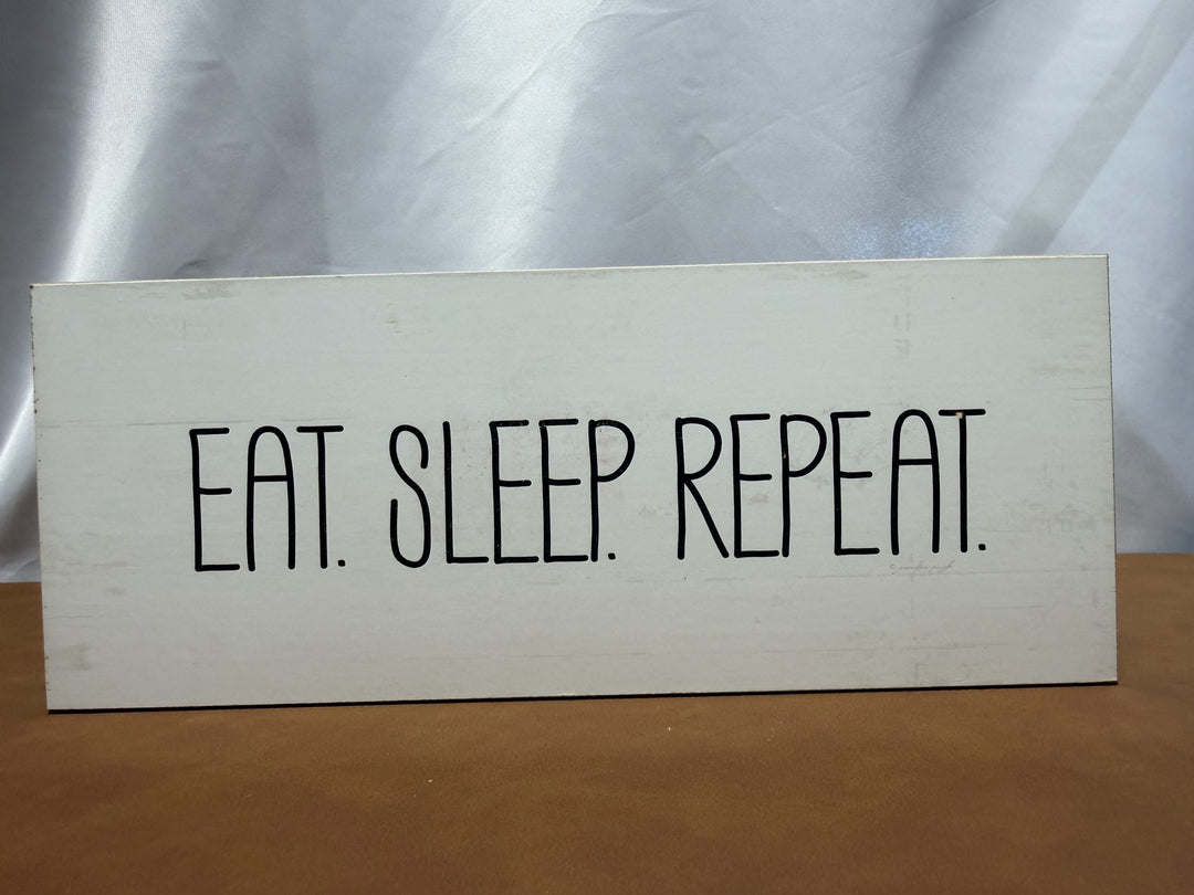 Wood sign reading Eat Sleep Repeat