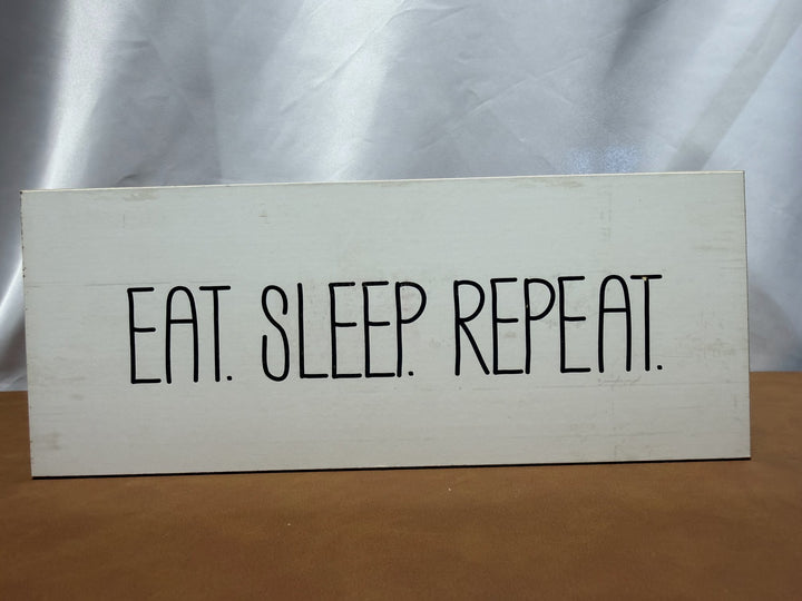 Wood sign reading Eat Sleep Repeat