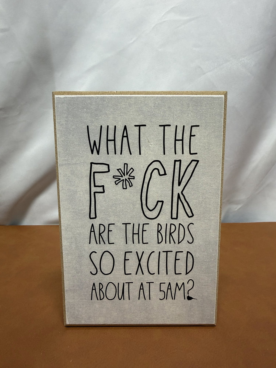 Wood sign joking about birds being loud at 5am