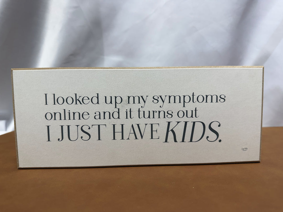 Wood sign joking about symptoms just being kids