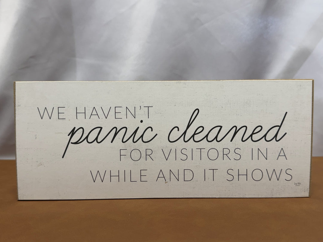 Wood sign joking about panic cleaning for visitors