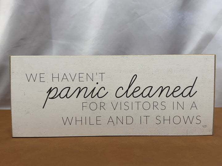 Wood sign joking about panic cleaning for visitors
