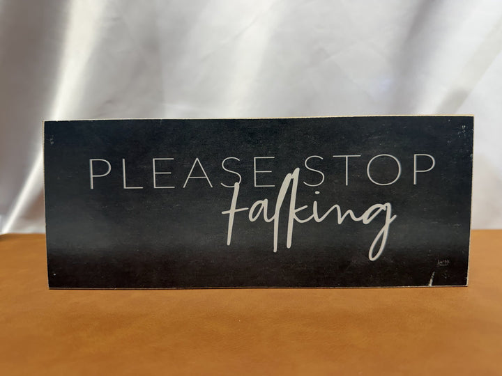 Wood sign reading Please Stop Talking