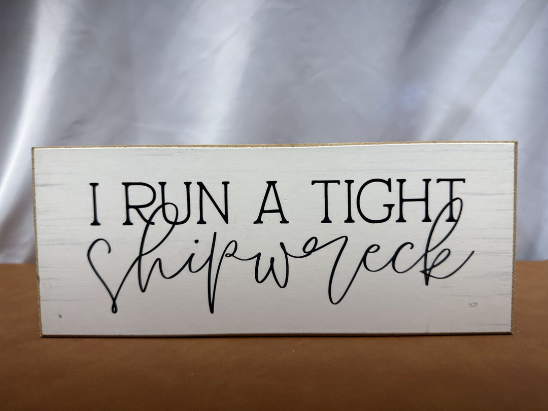 Wood sign reading I Run a Tight Shipwreck