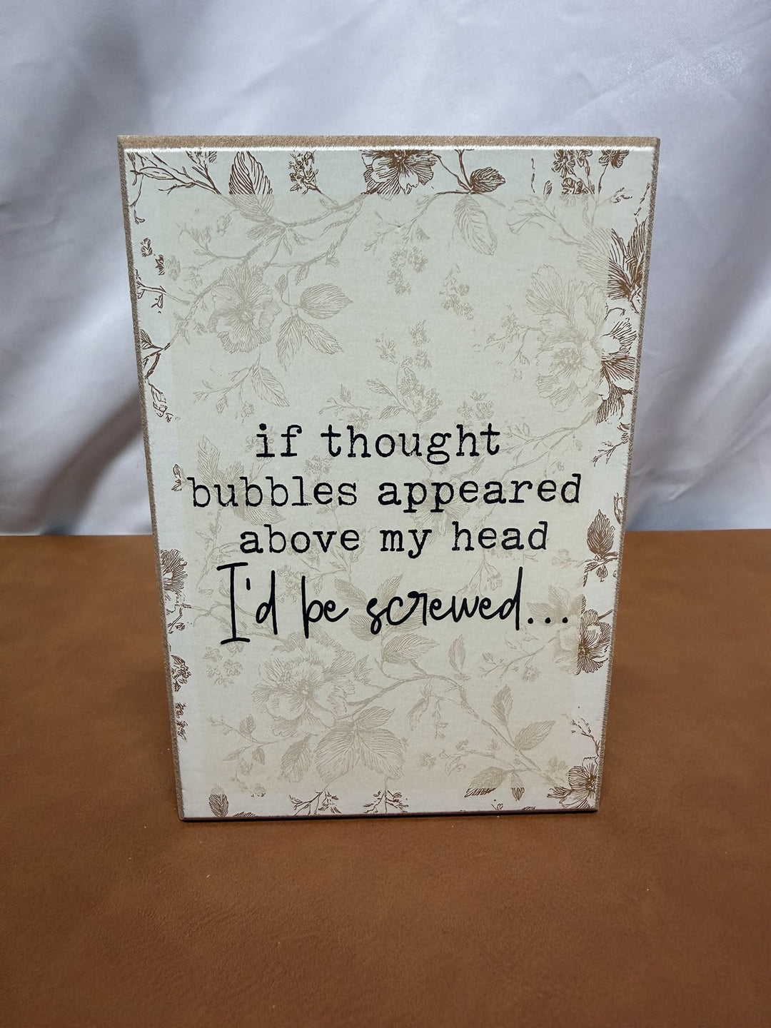 Floral wood sign joking about thought bubbles