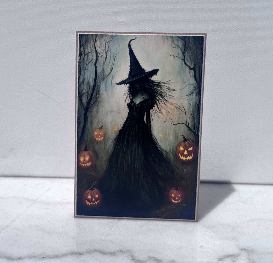 Witch silhouette surrounded by glowing jack-o-lanterns canvas print