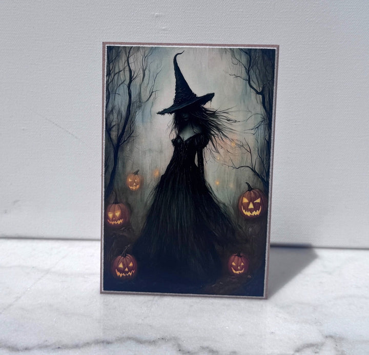 Witch silhouette surrounded by glowing jack-o-lanterns canvas print