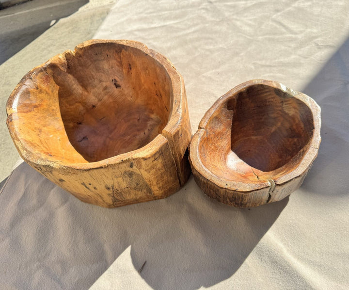 set of two handcrafted rustic teak root bowls with natural live-edge wood grain and polished finish.