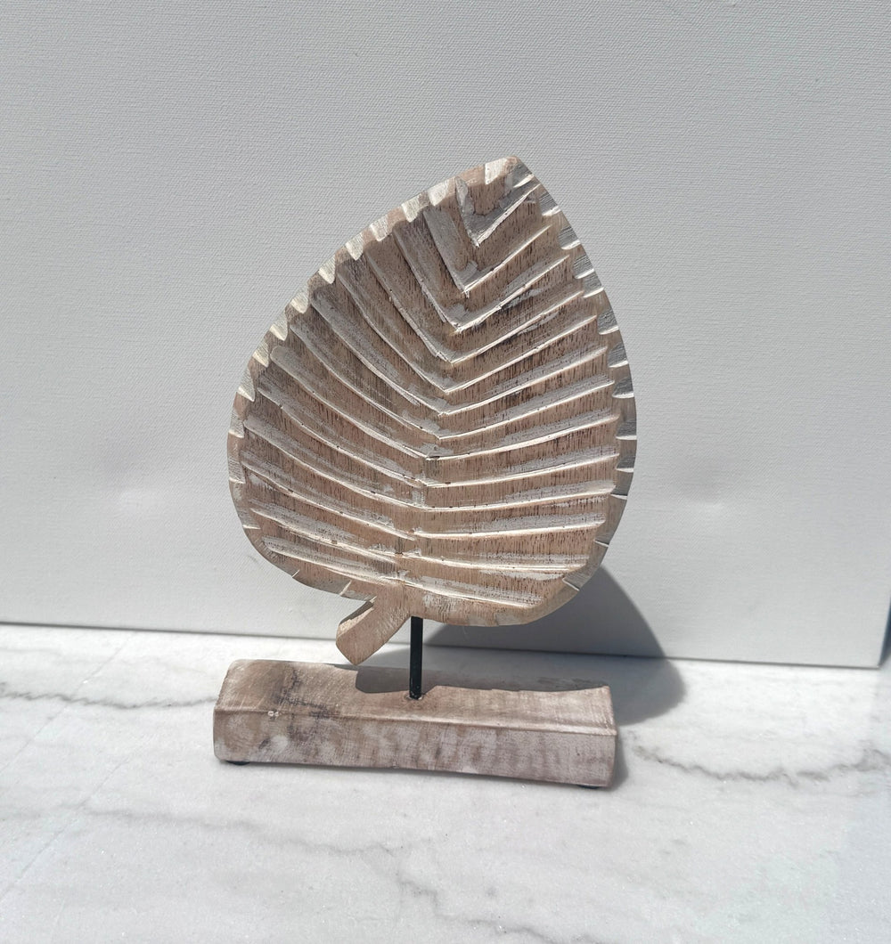 Whitewashed carved wood leaf on a stand
