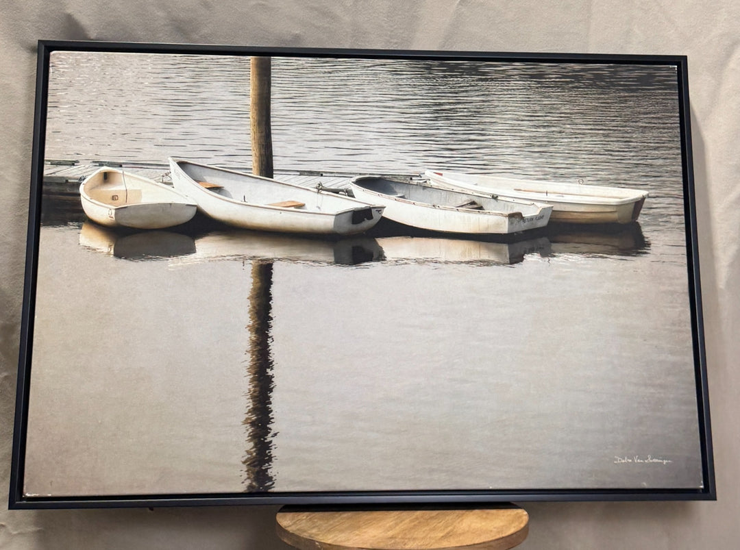 Neutral black and white rowboats on calm water framed canvas
