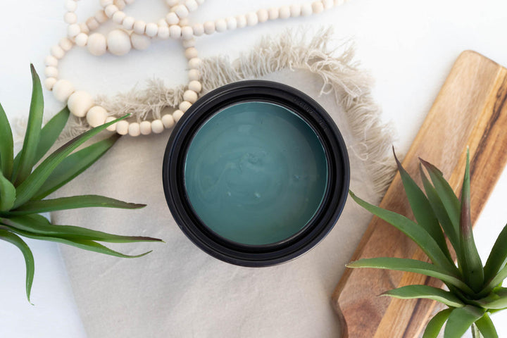 Open container of Blue Agave Terra Clay Paint styled with air plants and white beads