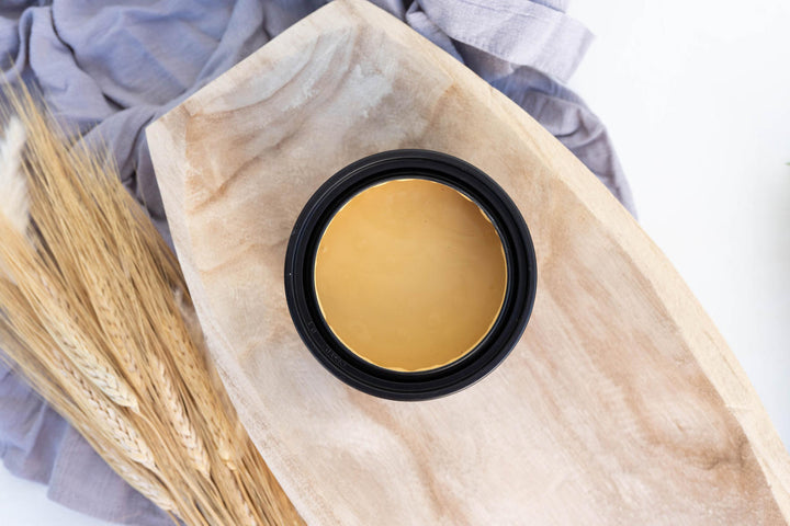 Open jar of Wheat Terra Clay Paint in a wooden bowl with wheat stalks